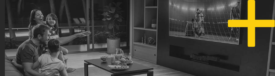 A family gathered in a living room watching TV, representing household or individual targeting through addressable TV.